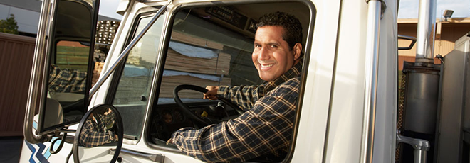 Camionneur souriant en regardant par la fenêtre de son camion