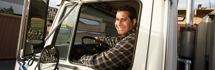 Camionneur souriant en regardant par la fenêtre de son camion