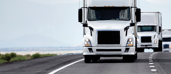 Three trucks driving on a highway