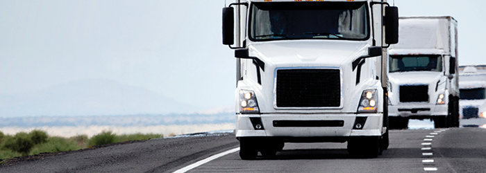 Three trucks driving on a highway