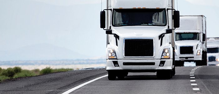 Three trucks driving on a highway