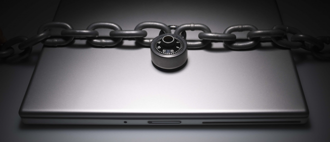 A laptop secured with a chain and padlock