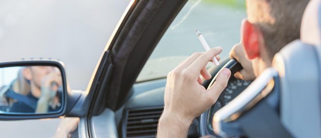 Man with cigarette in car.