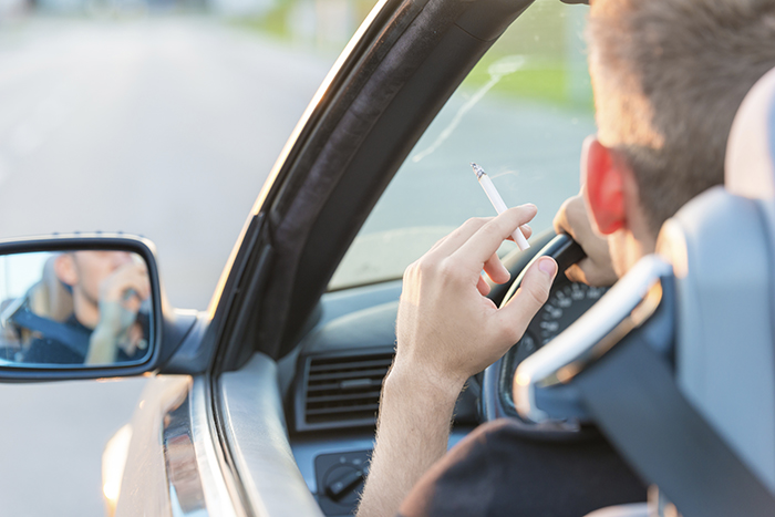 Man with cigarette in car.