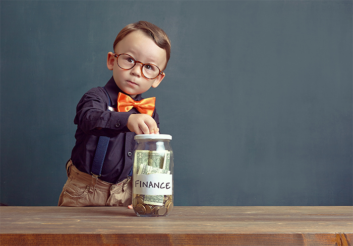 child putting money in a jar