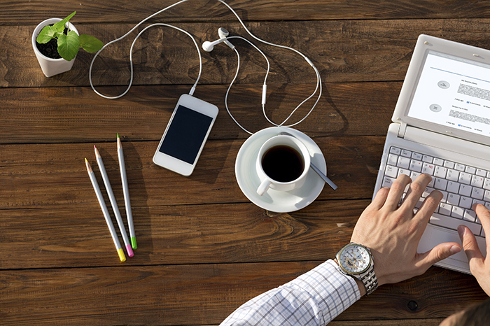 working at a table with coffee and smartphone