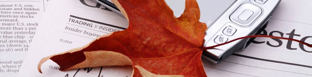 Red maple leaf on top of business documents on a table