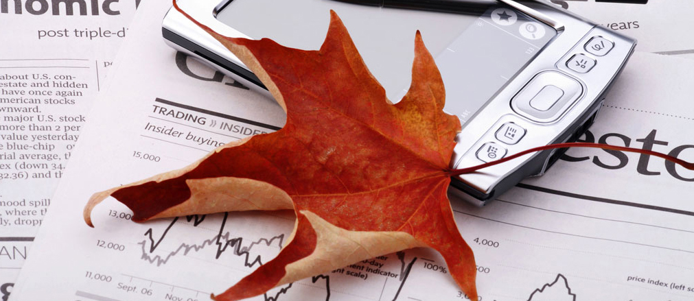Red maple leaf on top of business documents on a table