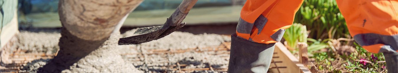 Worker with gum boots spreading ready mix concrete