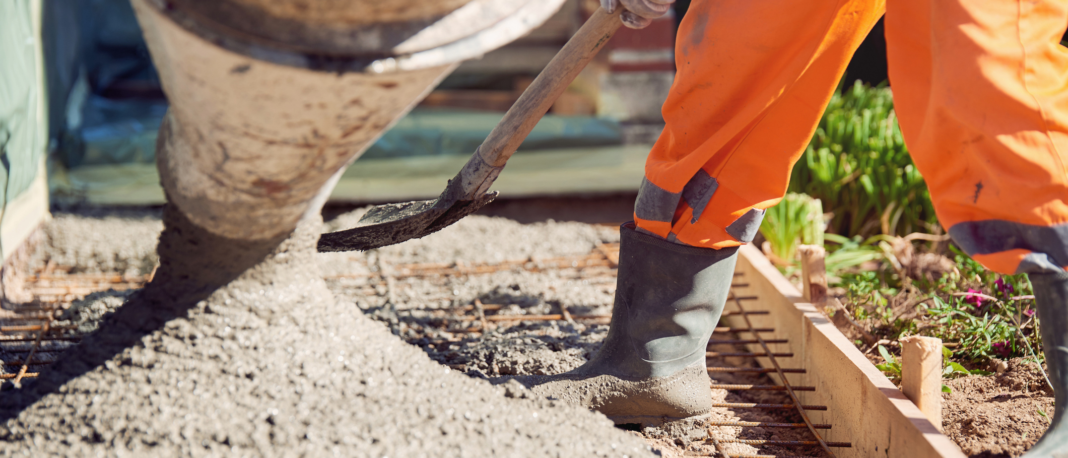 Worker with gum boots spreading ready mix concrete