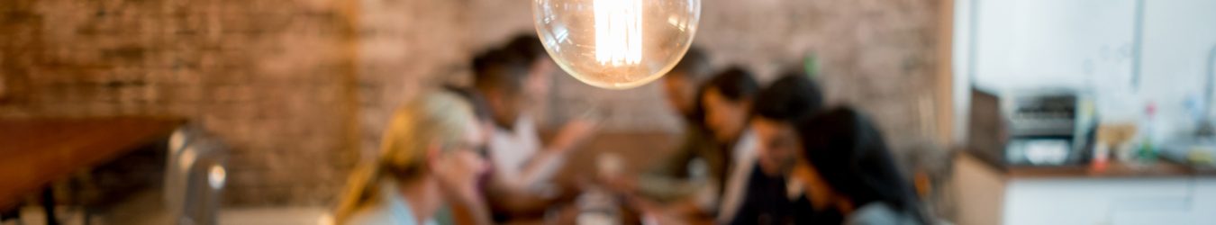 Brainstorming small business resources at a table under a light bulb.