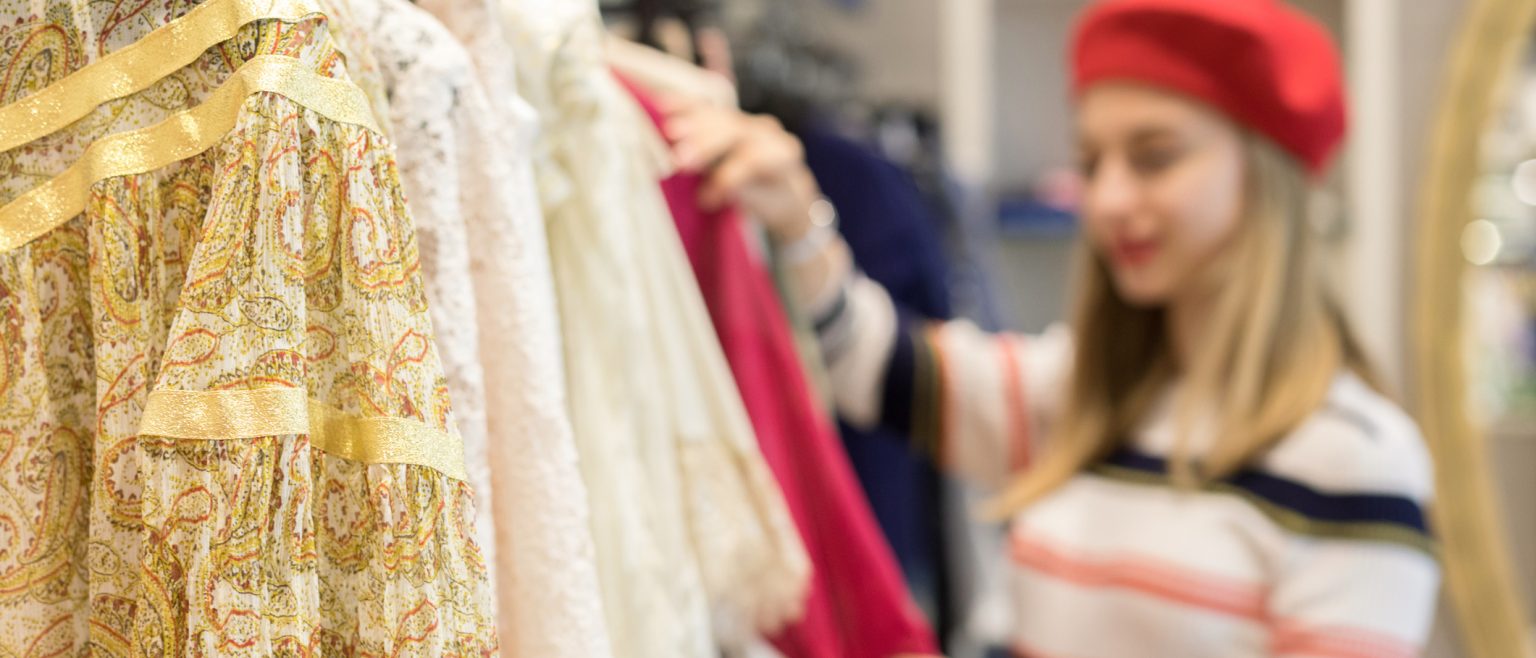 Young woman browsing a rack of clothing