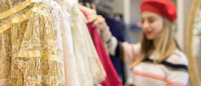 Young woman browsing a rack of clothing