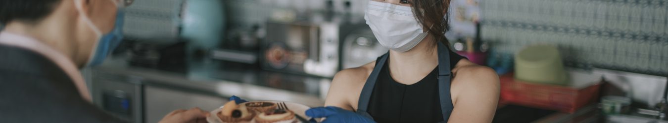 A waitress wearing a mask.