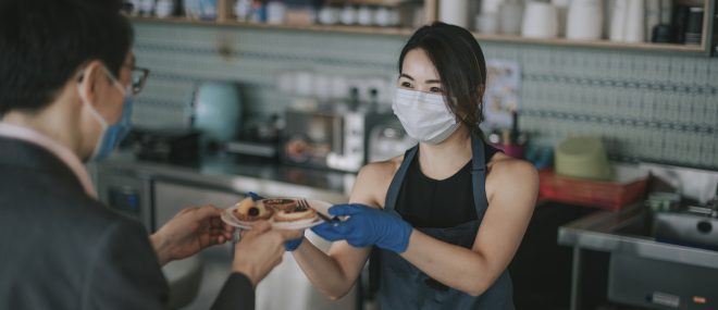 A waitress wearing a mask.