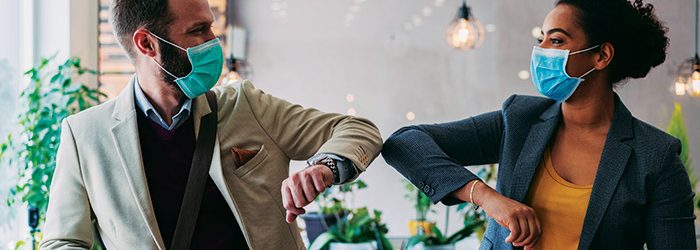 Business people greeting during pandemic with elbow bump