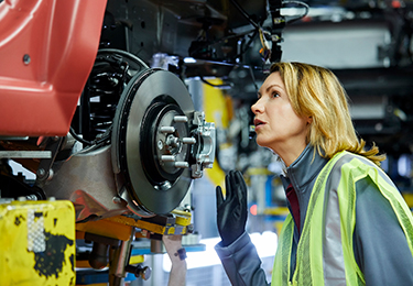 A female inspecting car parts.