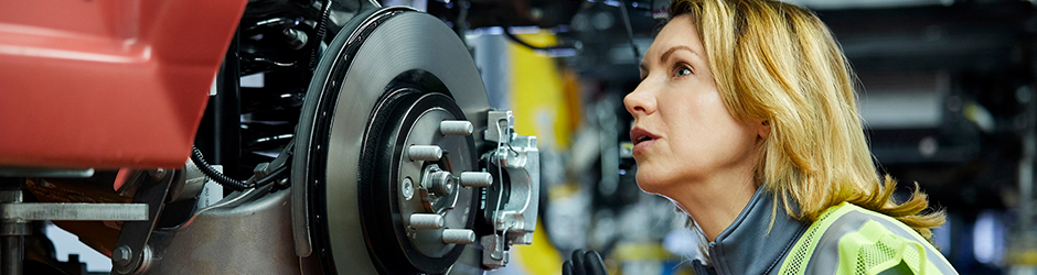 A female inspecting car parts.