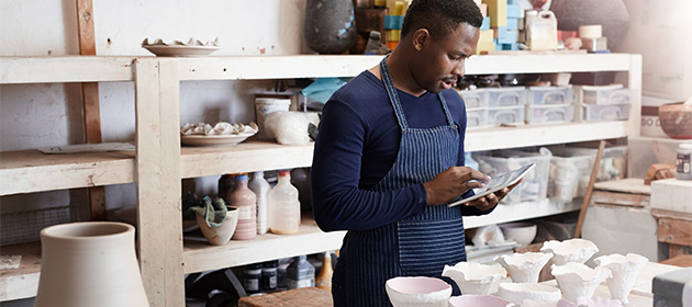 Male business entrepreneur working in his ceramics shop.