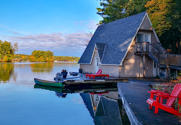 A-frame cottage by the water with a motorized boat