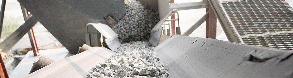 White concrete rocks on a conveyer belt.