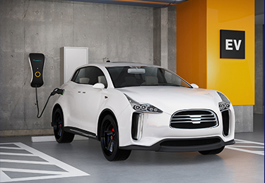 White electric car parked and plugged in an outlet inside a garage.