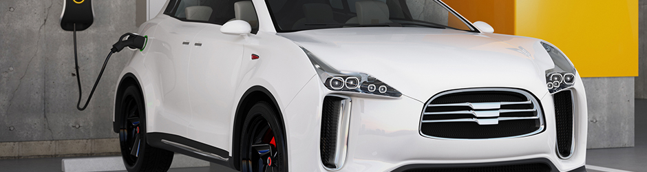 White electric car parked and plugged in an outlet inside a garage.