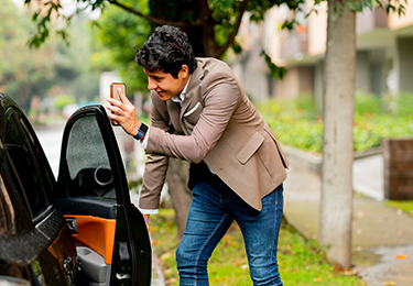 A person opening the passenger door of a black car.