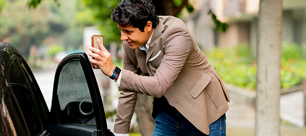 A person opening the passenger door of a black car.