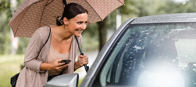 A woman outside the passenger side of a car confirming her ride.