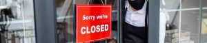 “Sorry we’re closed” sign hung on the front door of a shop.