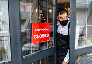 “Sorry we’re closed” sign hung on the front door of a shop.