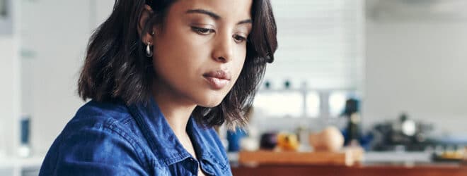 Young woman using a laptop and going through paperwork