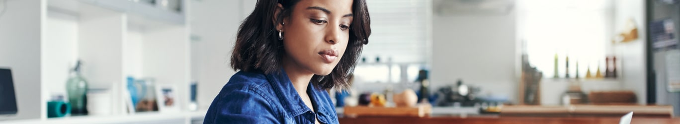 Young woman using a laptop and going through paperwork