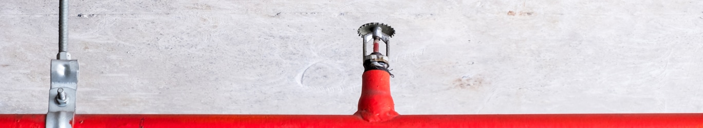 Automatic fire sprinkler on the red metal pipe.