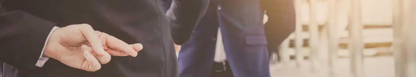 Businessman crossing his fingers behind his back.