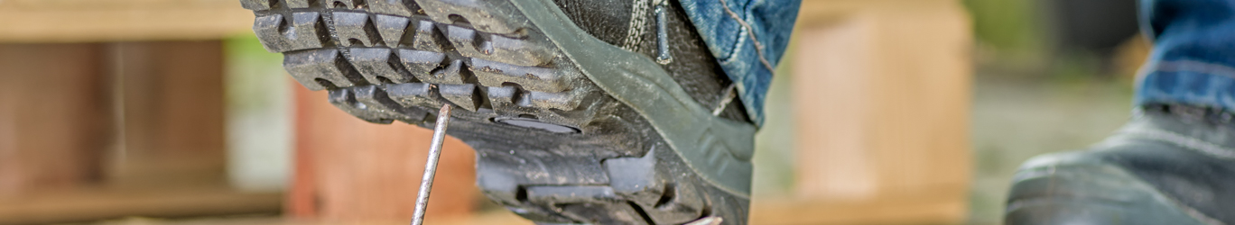 Worker with safety boots steps on a nail