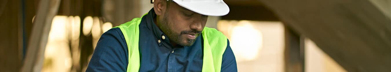 Male engineer holding digital tablet at site.