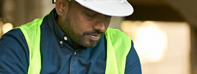 Male engineer holding digital tablet at site.