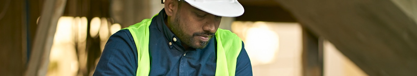 Male engineer holding digital tablet at site.