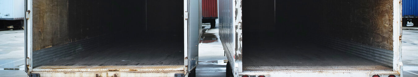 Two empty semi trucks side by side.