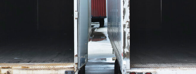 Two empty semi trucks side by side.