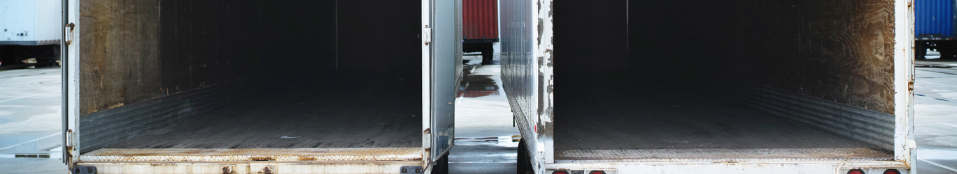 Two empty semi trucks side by side.