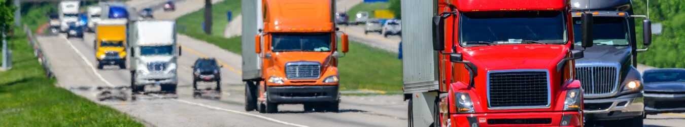 Multiple semi-trucks on the highway.