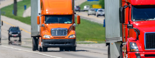 Multiple semi-trucks on the highway.