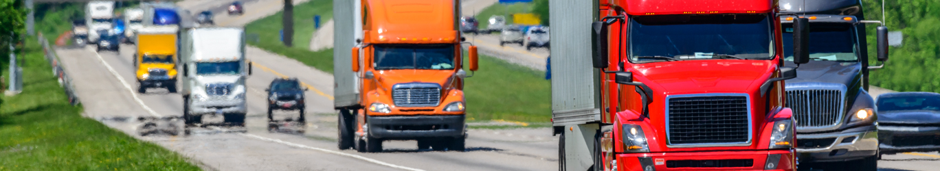 Multiple semi-trucks on the highway.