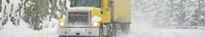 Semi truck driving in severe road conditions during a blizzard