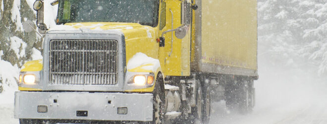 Semi truck driving in severe road conditions during a blizzard