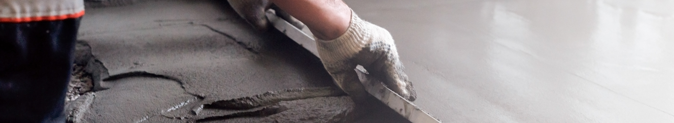 Worker levels a floor cement mortar