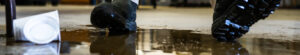 A worker in a warehouse walking in spilled liquid.